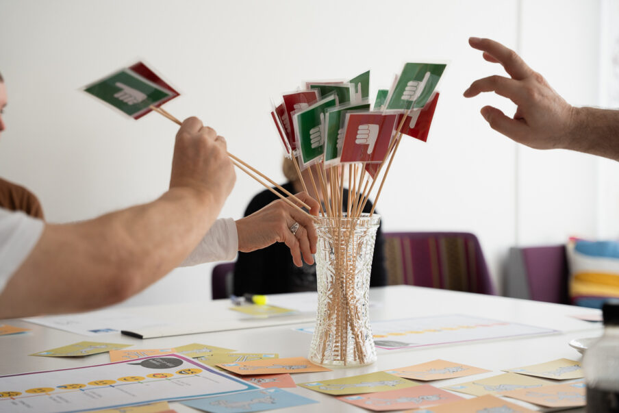 Kädet kurottavat kohti kyllä- ja ei -kortteja