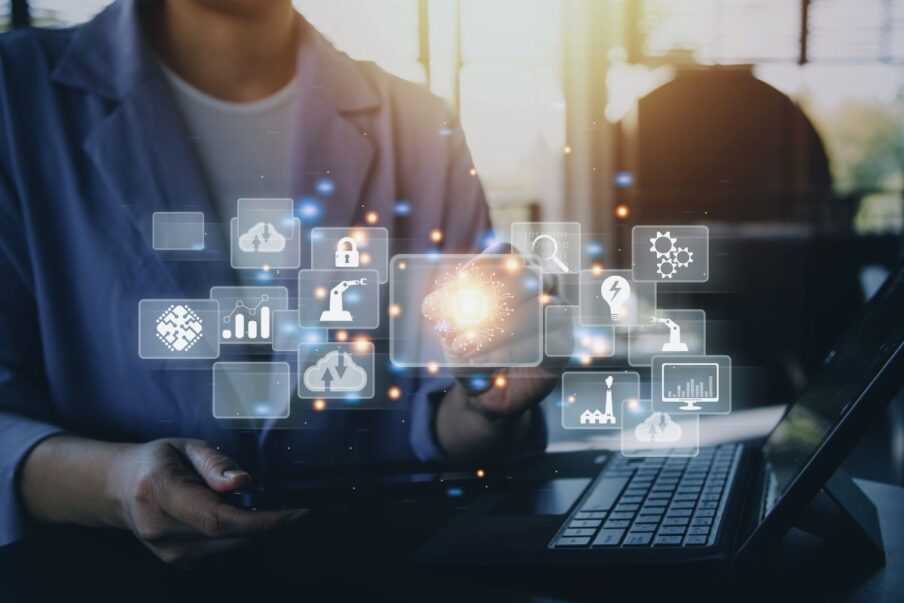 ihmishahmo tietokoneen ääressä. Etualalla erilaisia ikoneita.