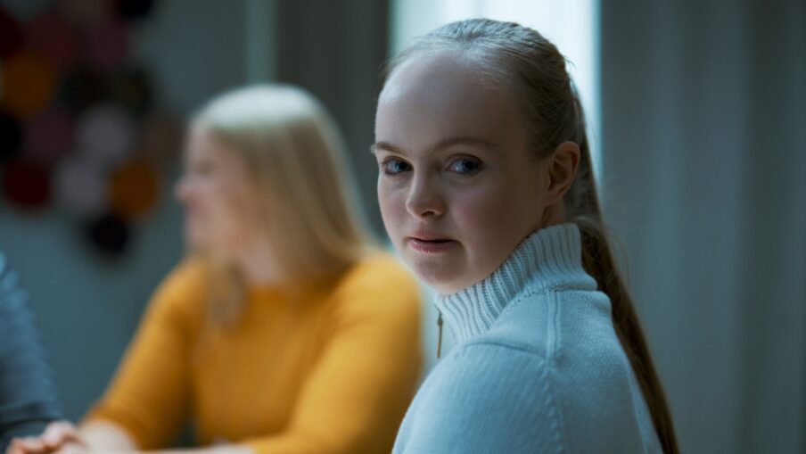 Kuvassa nuori nainen katsoo kameraan tiukka ilme kasvoillaan.