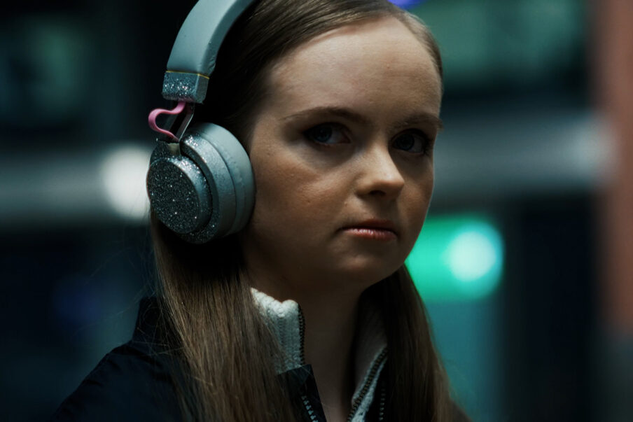 Young woman wearing headphones looking over her shoulders.